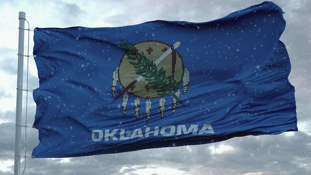 Bandiera invernale dell'Oklahoma con sfondo di fiocchi di neve.  Stati Uniti d'America.  rappresentazione 3D