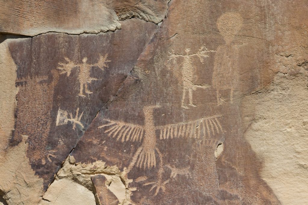 Strane forme e figure che sono state scolpite nelle antiche rocce di arenaria insieme a graffiti più moderni nel sito dei petroglifi di Legend Rock State, nel Wyoming.