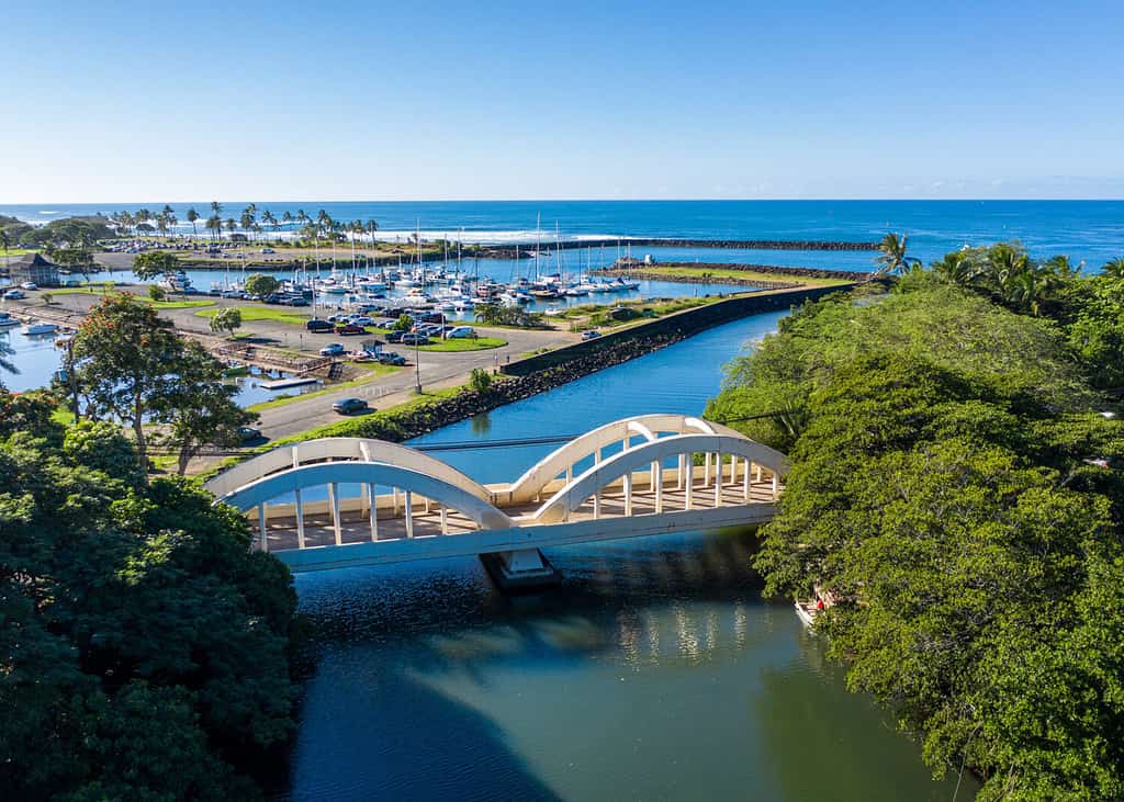 Ripresa aerea del fiume Anahulu e del ponte stradale ad arco gemello nella città di Haleiwa sulla North Shore