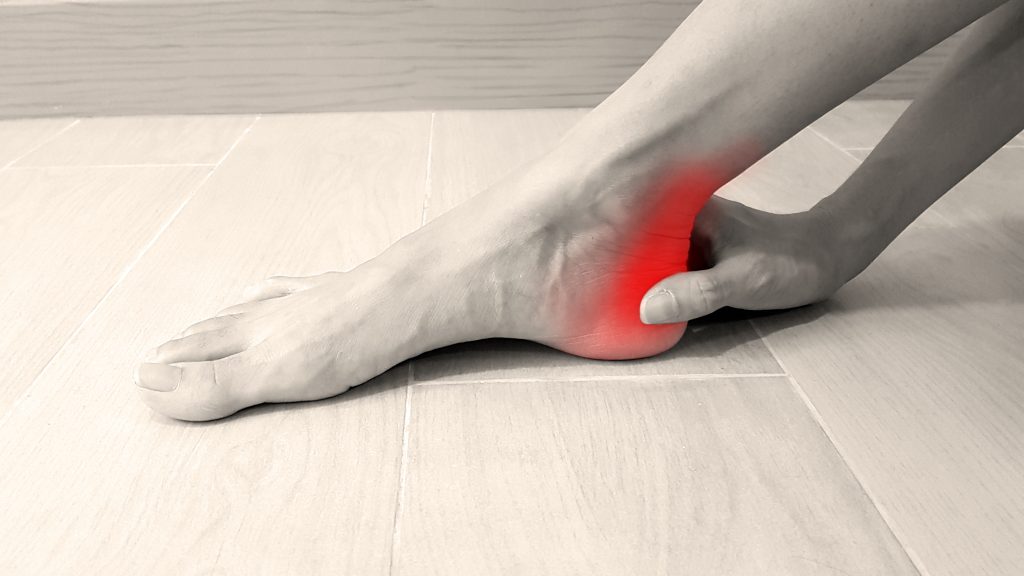 Anatomia del piede con evidenziazione rossa sulla zona dolorante.  Il dolore alla caviglia può essere causato da affaticamento muscolare, tendinite dell'Achille, distorsione dei legamenti, artrite, frattura ossea o borsite.  Concetto di sintomo medico