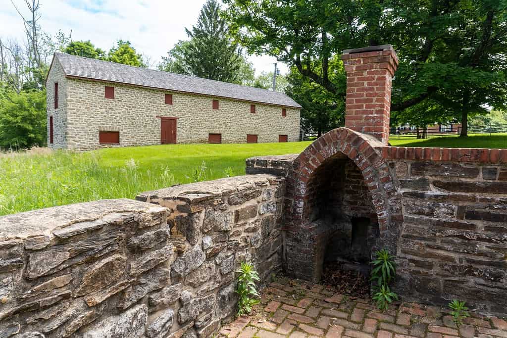 Towson, Maryland -2022: Sito storico nazionale di Hampton.  Granaio della Long House e camino esterno.  La struttura in pietra a due piani fungeva da stalla per maiali e granaio durante il periodo storico.