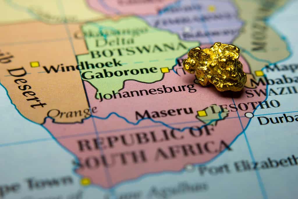 Primo piano di una pepita d'oro sopra una mappa del Sud Africa