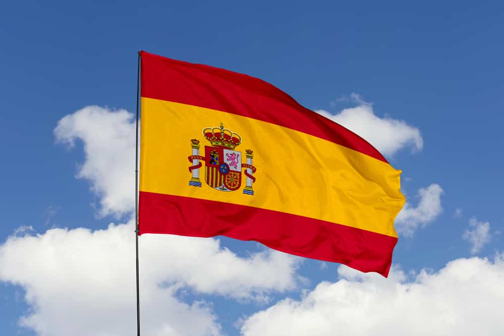 Bandiera della Spagna isolata sul cielo blu con tracciato di ritaglio.  primo piano sventolando la bandiera della Spagna.  simboli della bandiera della Spagna.