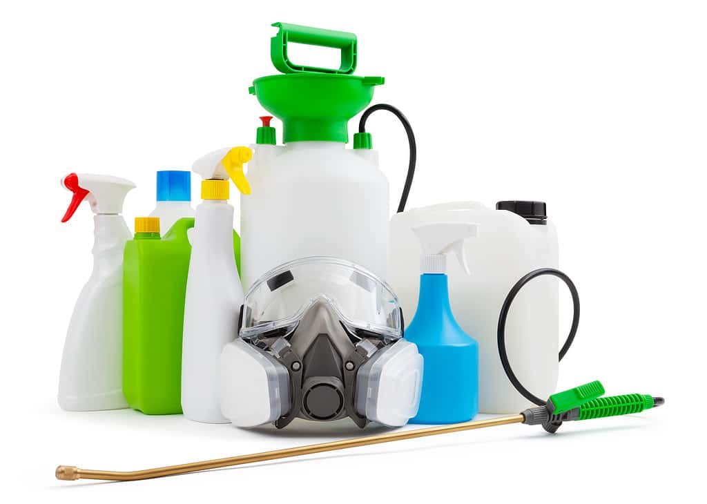 Kit di strumenti per la pulizia e la disinfezione, isolati su sfondo bianco.  Maschera respiratoria protettiva, nebulizzatore con pompa manuale e tanica per distruggere i batteri domestici e i pesticidi per le piante da giardinaggio