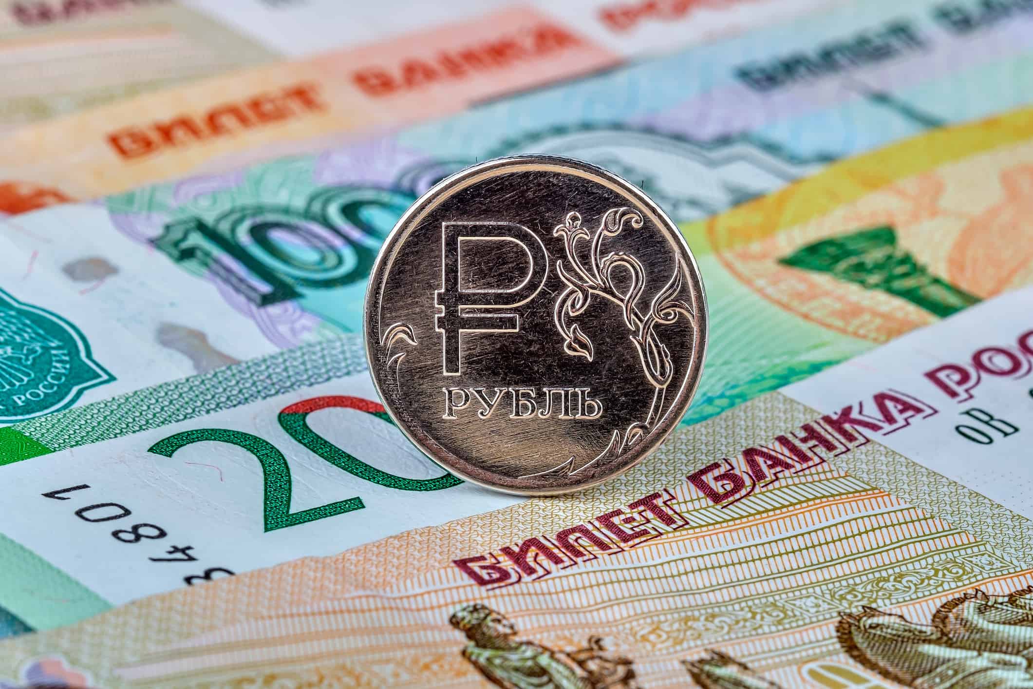 Moneta da un rublo russo in valuta cartacea, sfondo di varie banconote.