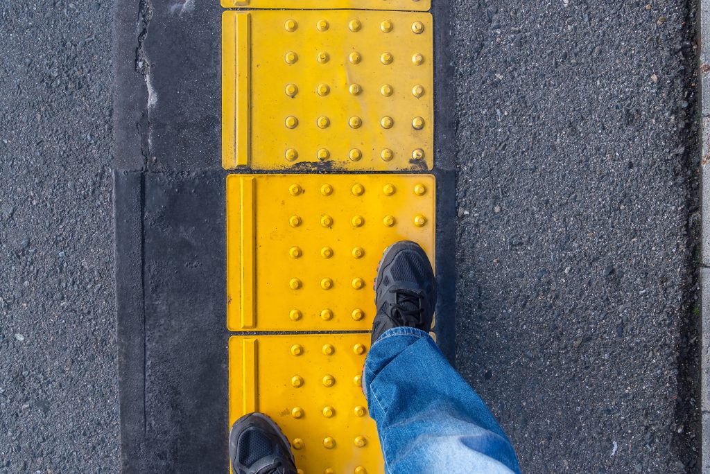 Blocco Braille dritto per non vedenti sul passaggio pedonale.  Indicatori tattili da superficie per non vedenti e ipovedenti.
