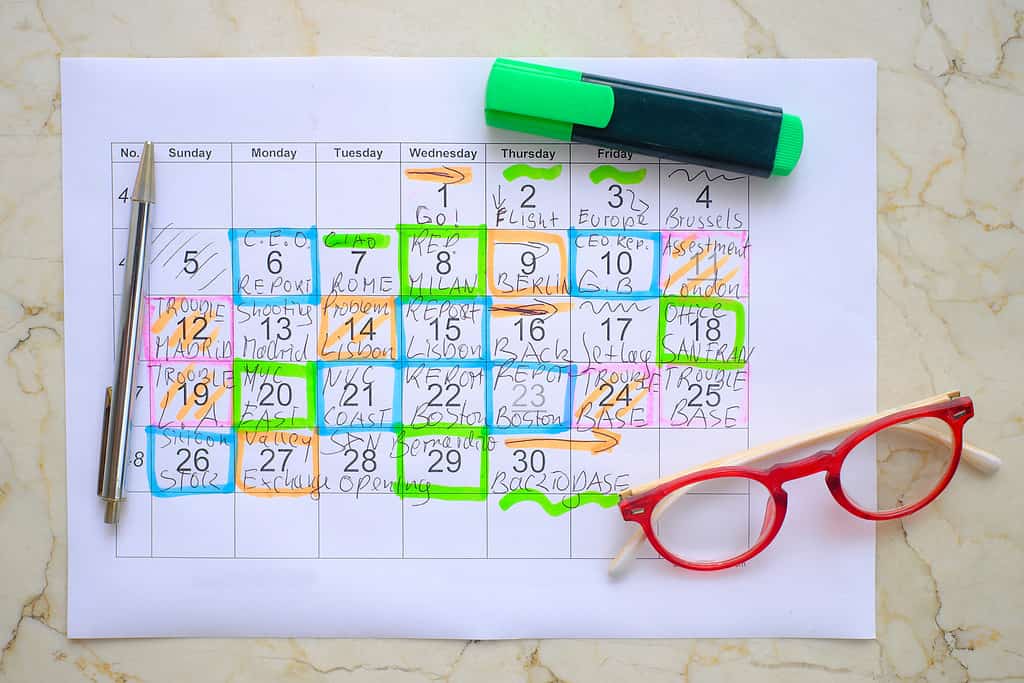 Calendario con appuntamenti di lavoro, penna e occhiali, pianificazione mensile