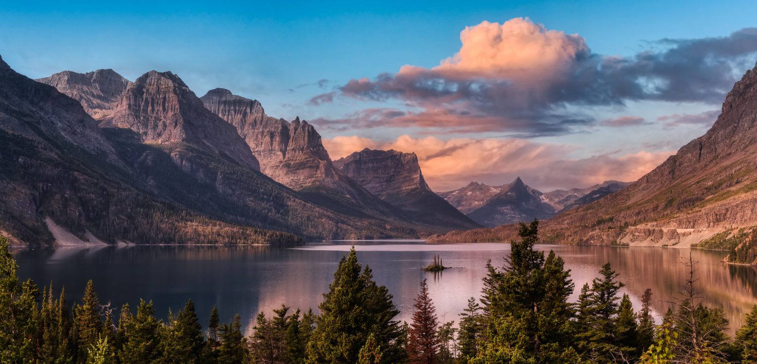 Bellissima vista panoramica di un lago glaciale con il paesaggio delle montagne rocciose americane sullo sfondo.  Drammatico cielo colorato di alba.  Preso nel Glacier National Park, Montana, Stati Uniti.