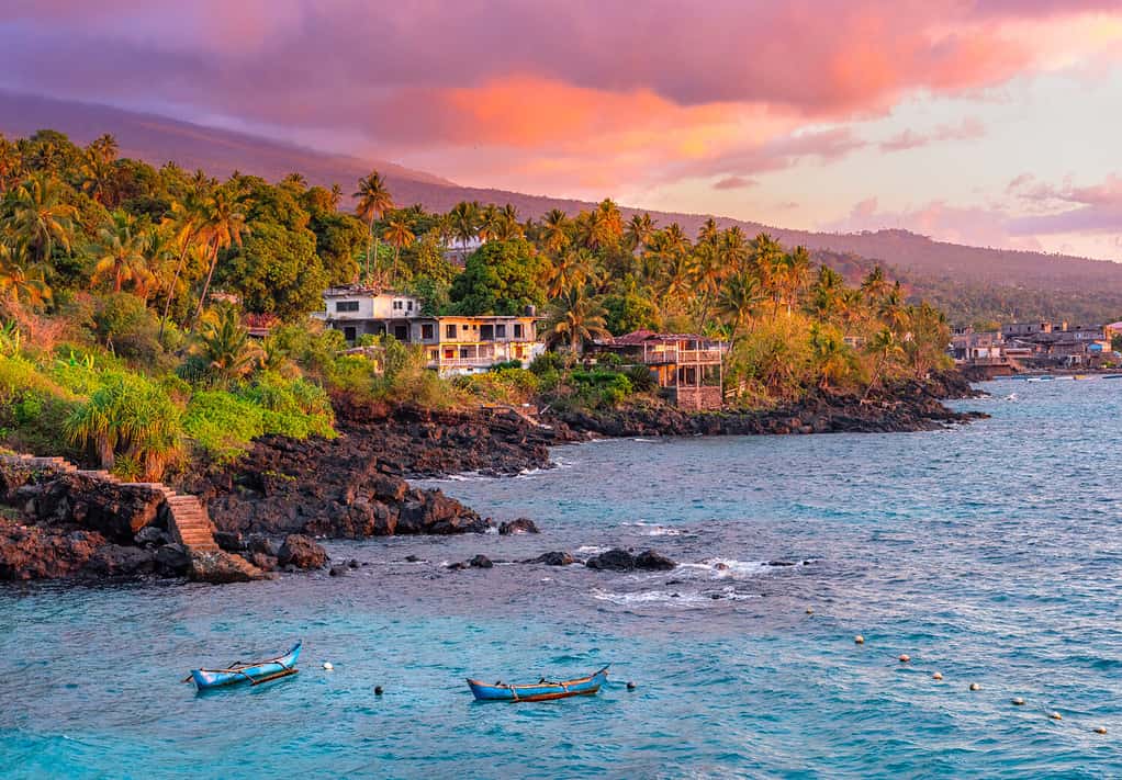 Barche al tramonto in un paradiso per le vacanze sull'isola di Grand Comore, Comore.  Bella luce del tramonto del sole nel mare.  Ville sulla spiaggia con spiaggia privata.  Moroni Comore, hotel resort sulla spiaggia di Itsandra