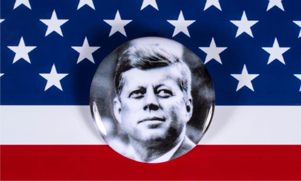 Un distintivo di John F. Kennedy raffigurato sopra la bandiera degli Stati Uniti