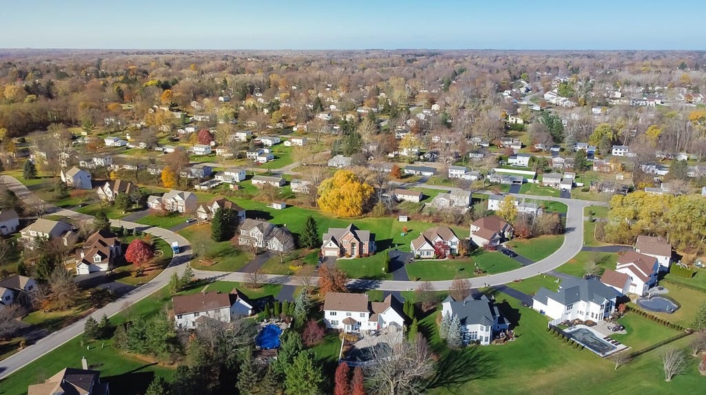 Vista aerea casa residenziale a due piani a bassa densità nella periferia di espansione verso l'esterno dello sviluppo sprawl di Rochester, New York.  Casa suburbana di lusso con lotto di grandi dimensioni, prato erboso verde, stagione autunnale