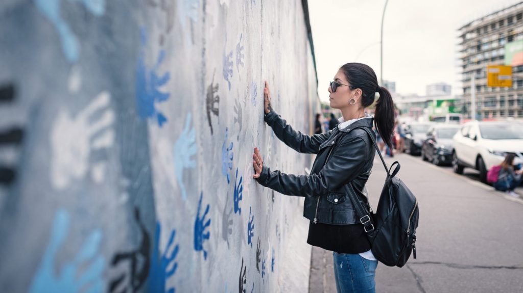 Giovane donna davanti al muro di Berlino.