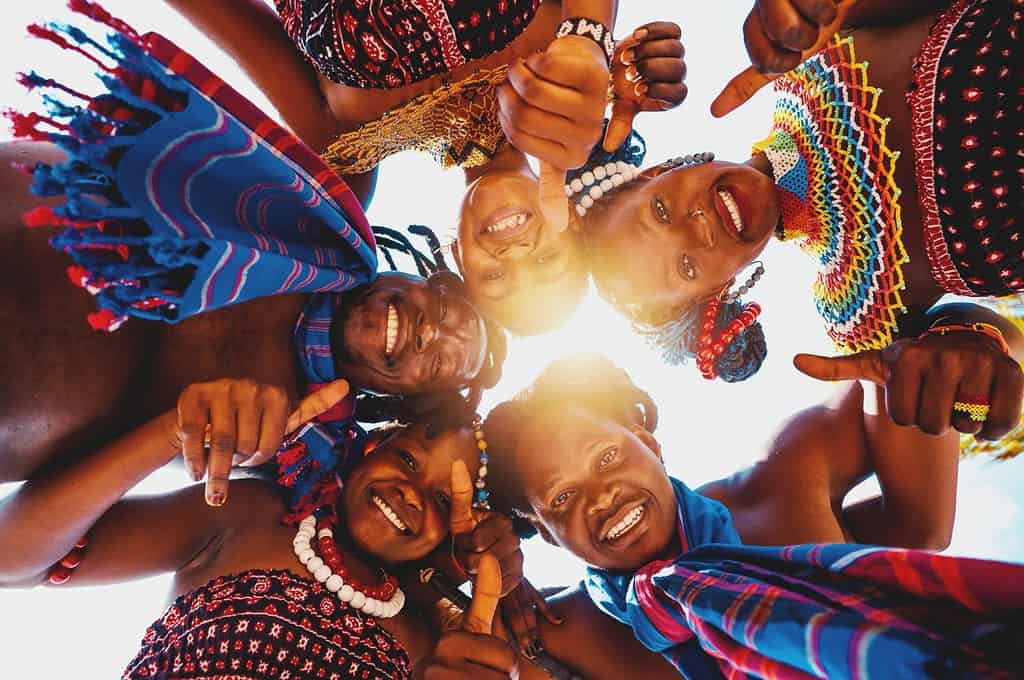 La gente del posto con i tipici abiti kenioti si abbraccia e sorride insieme