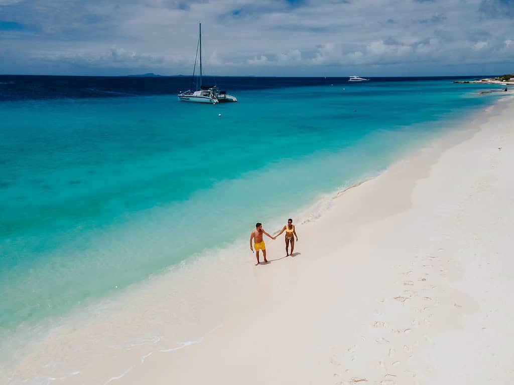 Piccola isola di Curacao famosa per gite di un giorno e tour di snorkeling su spiagge bianche e oceano cristallino, l'isola di Curacao nel Mar dei Caraibi.  una coppia di uomini e donne sulla spiaggia durante una vacanza