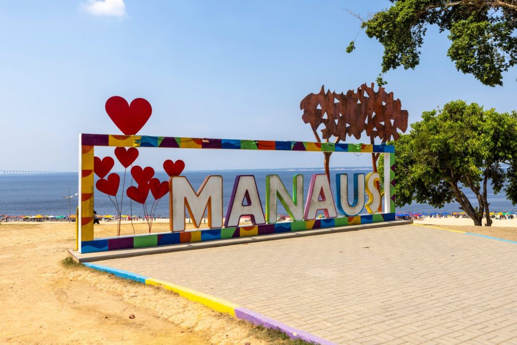 MANAUS scritto in grandi lettere luminose con cornice colorata a Praia Ponta Negra, la spiaggia di Ponta Negra, nella metropoli della giungla Manaus, nel cuore della foresta amazzonica del Brasile, Sud America