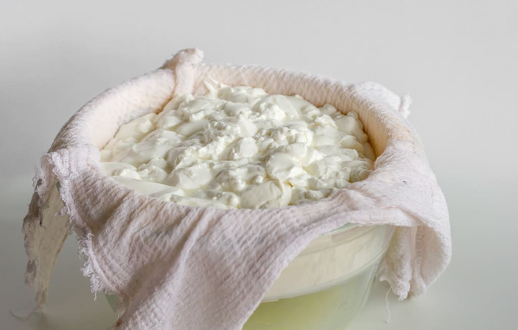 Pasticcio di formaggio fermentato o ricotta o yogurt greco su un asciugamano per waffle per separarlo dal siero di latte