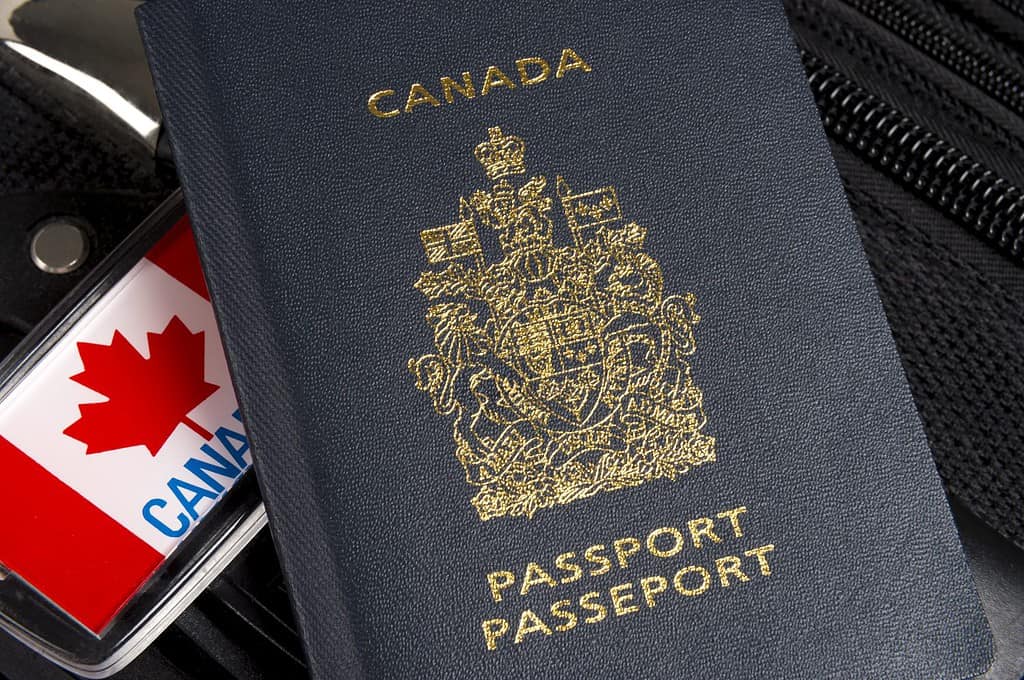 Primo piano del passaporto canadese seduto sulla valigia con etichetta per bagagli in foglia d'acero