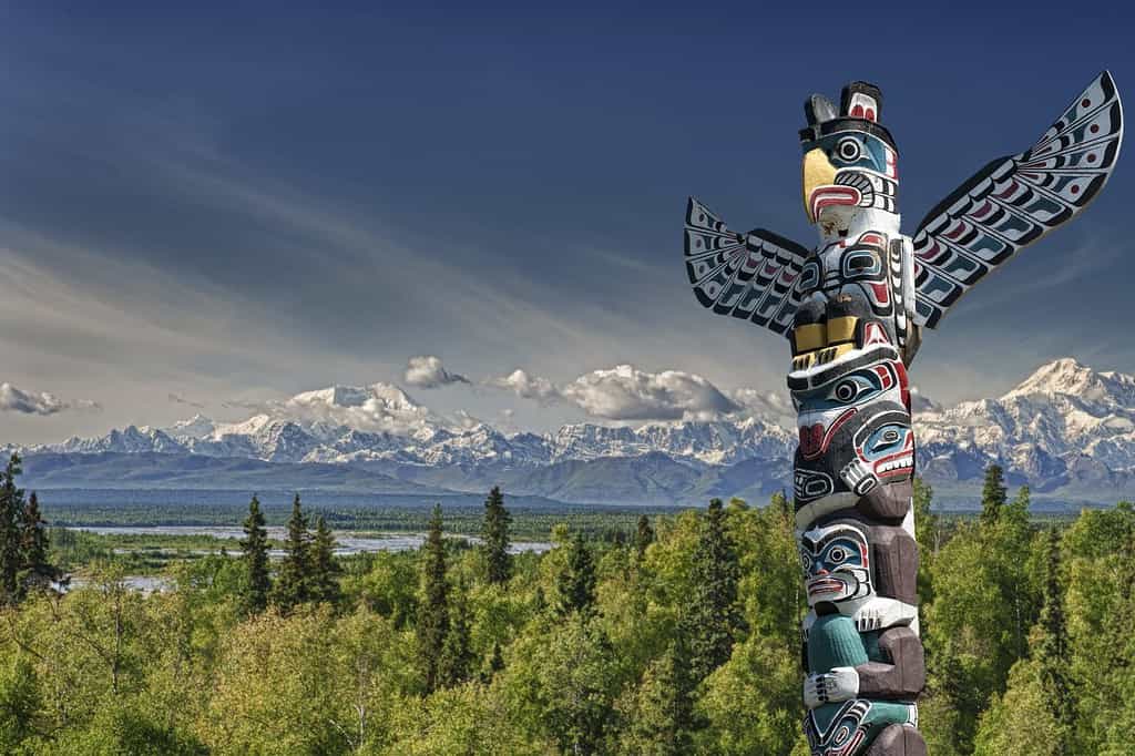 Palo di legno totem isolato su sfondo blu di montagna