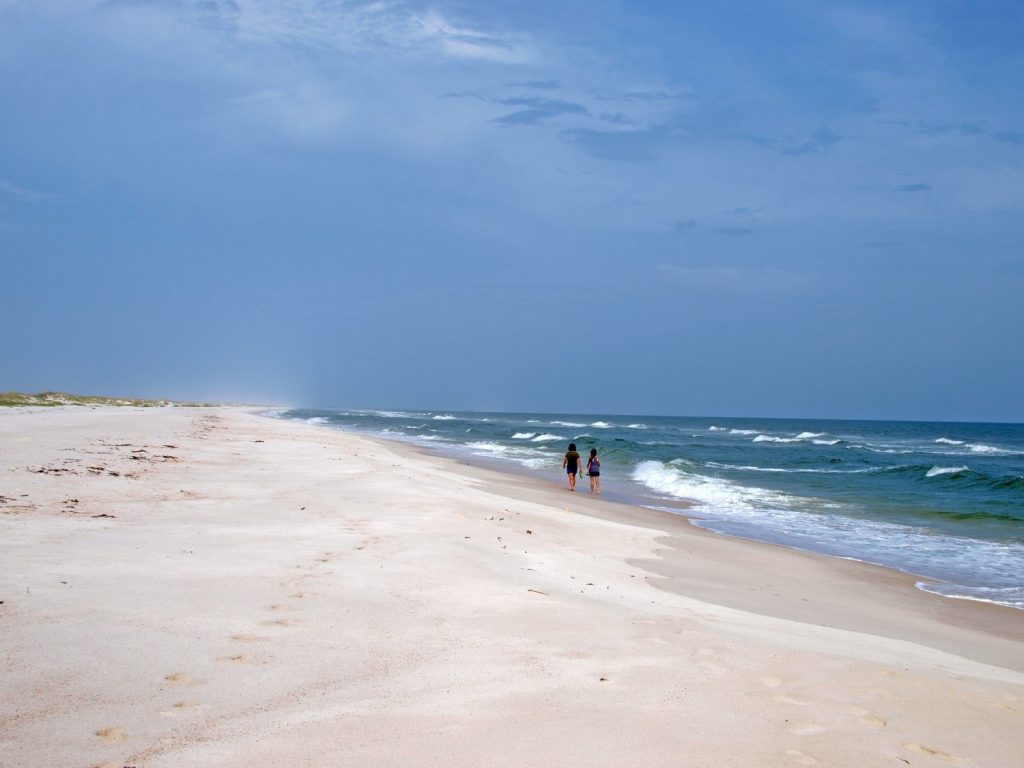 Signore che camminano nella spiaggia deserta del Parco statale di St. George Island nel Golfo del Messico.