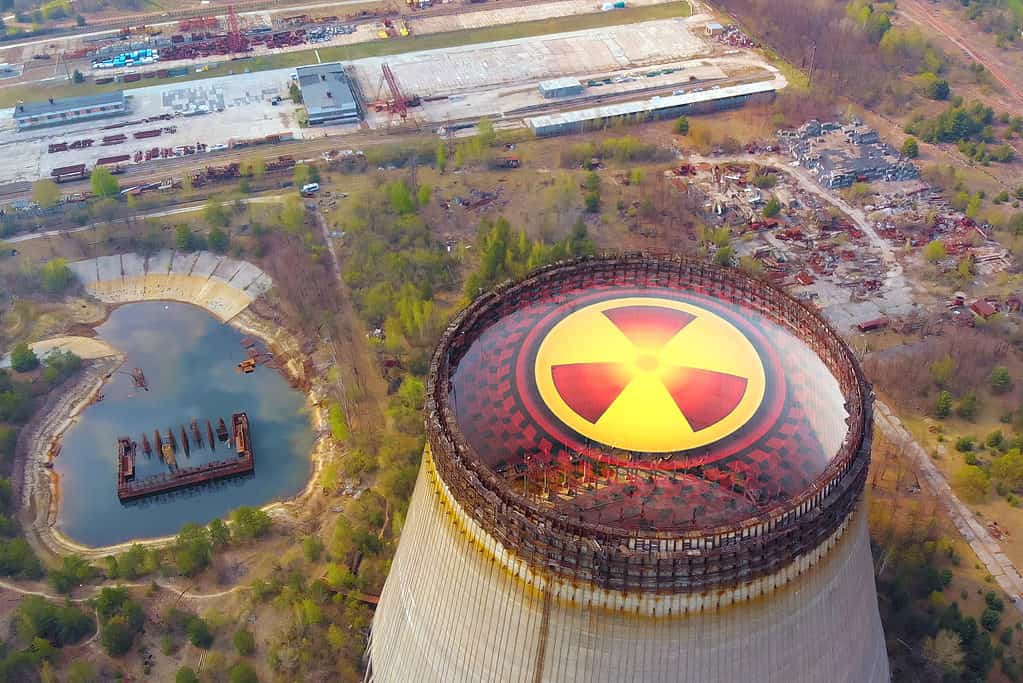 Disastro di Chernobyl. Zone radioattive vicino al reattore di Chernobyl. Segno di radiazioni sullo sfondo della torre di raffreddamento di Chernobyl. Area di contaminazione da radiazioni vicino al reattore di Chernobyl.