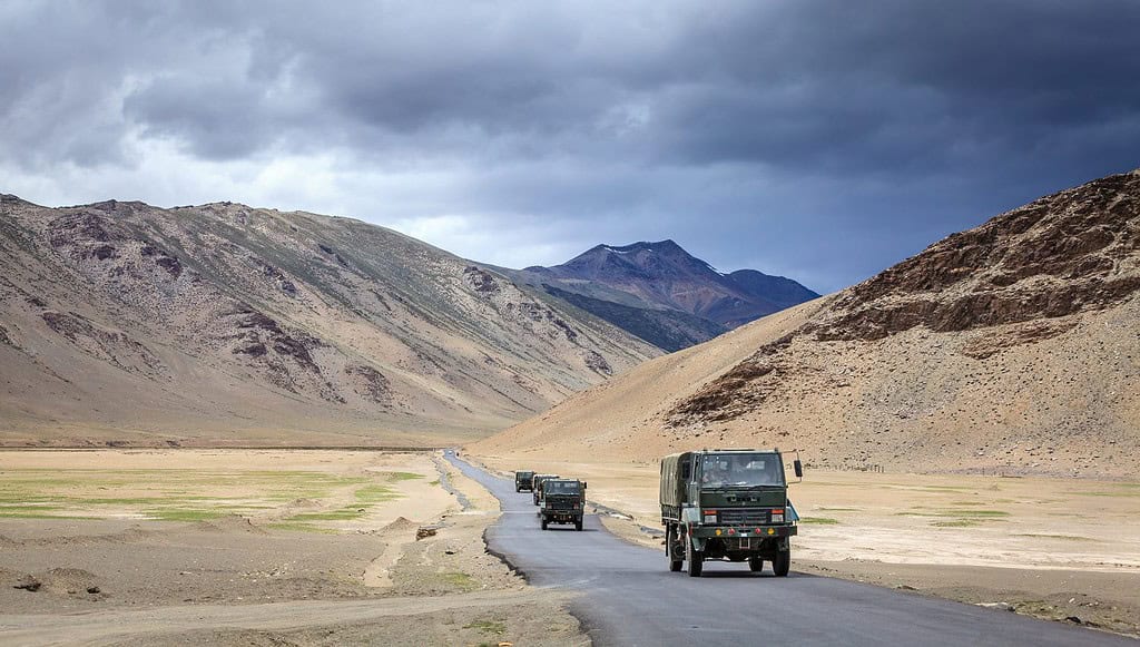 Un convoglio di camion militari si sta muovendo attraverso l'altopiano di Changthang, nella regione del Ladakh, nel Kashmir, in India.