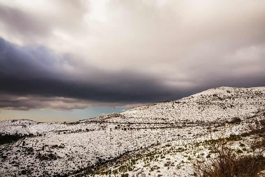 Area montuosa del Pentelico (Pentelikon) vicino ad Atene, Grecia coperta di neve con cielo nuvoloso come sfondo. Pittoresco paesaggio invernale. Inverno innevato
