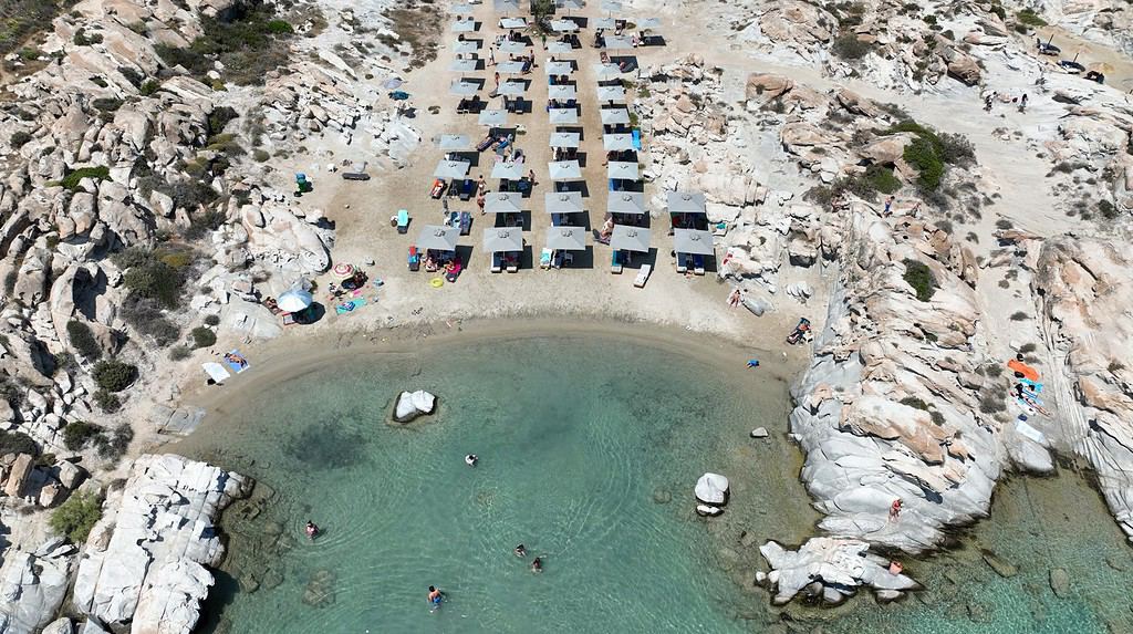 Foto aerea scattata con drone della famosa piccola spiaggia organizzata con formazioni rocciose uniche di Kolimbithres o Kolympethres nel golfo di Naousa, isola di Paro, Cicladi, Grecia