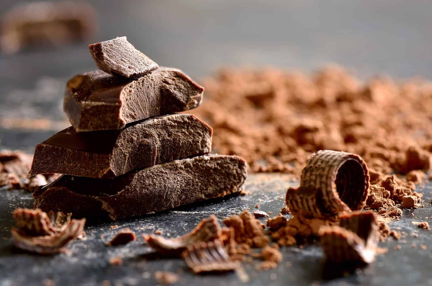 Pila di cioccolato fondente, scaglie e polvere