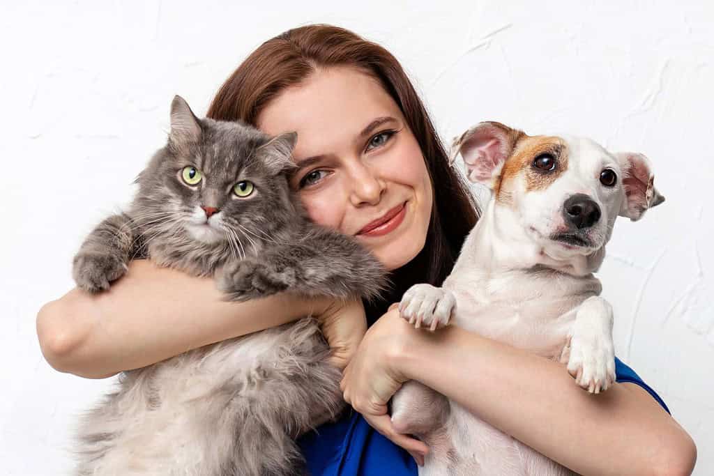 Una ragazza con il suo gatto e il suo cane