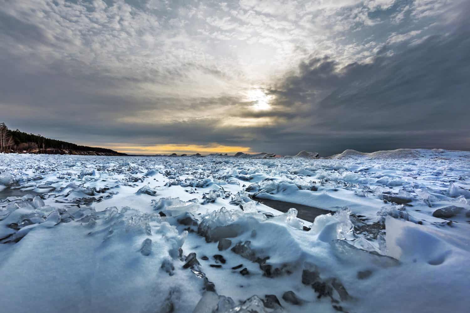 L'inizio dell'era glaciale sul fiume Ob con collinette di neve e ghiaccio al largo della costa. Berdsk, regione di Novosibirsk, Siberia occidentale della Russia, novembre