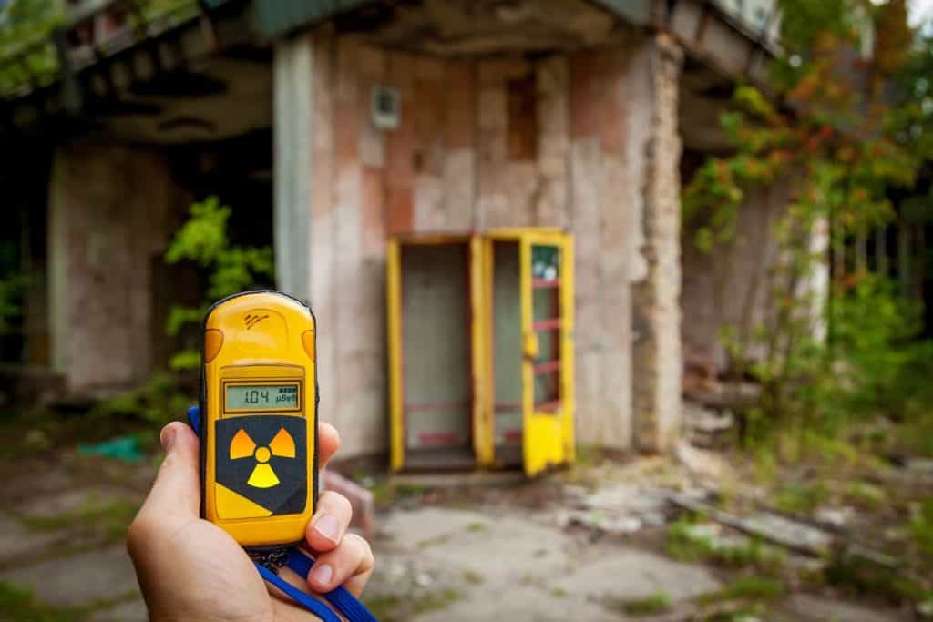 Un dosimetro in mano con un livello di radioattività nella città di Pripyat, una città fantasma della centrale nucleare di Chernobyl colpita da un disastro nucleare nel 1986, zona di esclusione di Chernobyl, Ucraina.
